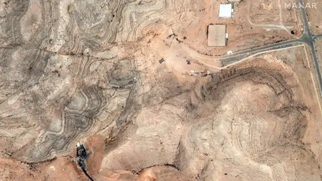 A satellite image shows airstrike damage to the tunnel entrances of the Isfahan Nuclear Technology Research Center. The image is sand coloured and shows some blackened areas