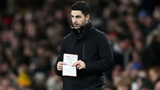 Mikel Arteta, Manager of Arsenal, holds a notepad