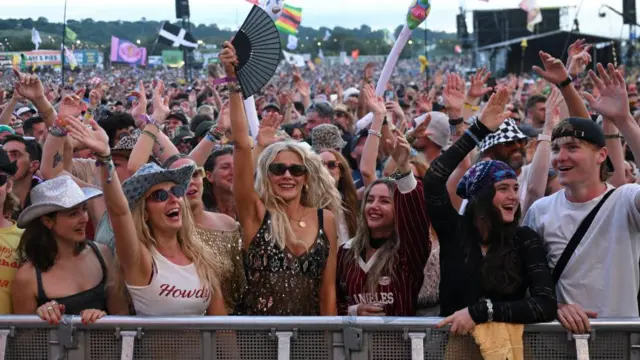 Glastonbury'deki kalabalık, birçoğu havada kollarıyla dans ediyor