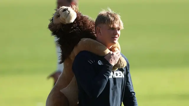 Henry Pollock carries the British & Irish Lions mascot BIL