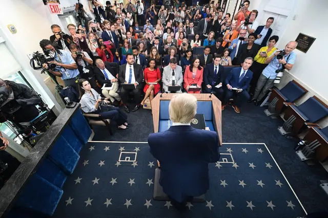 Reporters in audience while president stands at podium