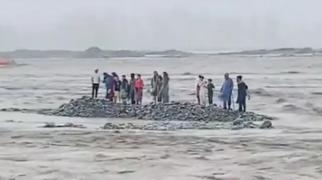 This screengrab from one video shows a group of people stranded in the river