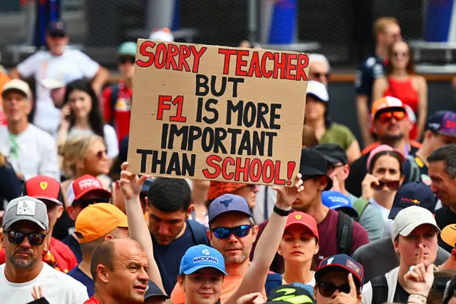 Fan hold a sign which reads "sorry teacher but F1 is more important than school"