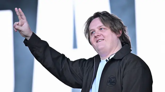 Lewis Capaldi holds the peace sign up on stage at Glastonbury