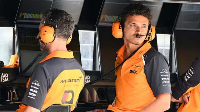 Lando Norris sat at the pit wall