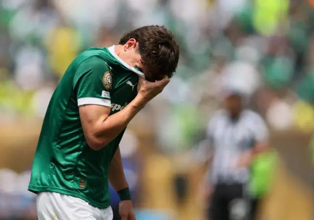 Giay covers his face with his shirt after an awful miss