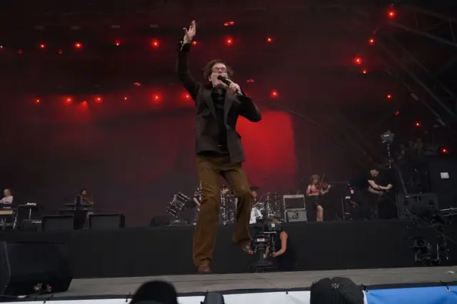 Jarvis Cocker jumping on the Pyramid stage while singing into his microphone