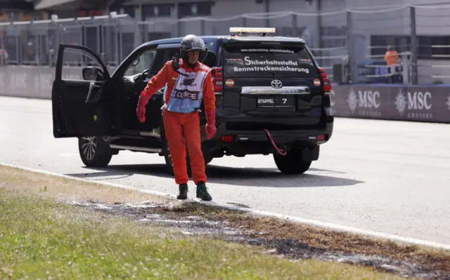 A marshal attends to a grass fire at the Red Bull Ring