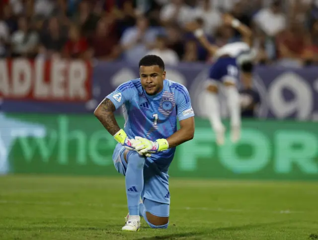 German keeper puffs out his cheeks as he gets up from a dive