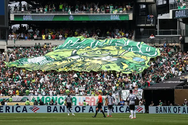 Palmeiras fans hold up a banner behind the goal