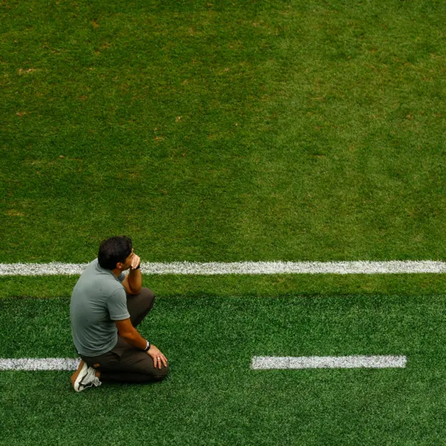 Ferreira kneels in his technical area