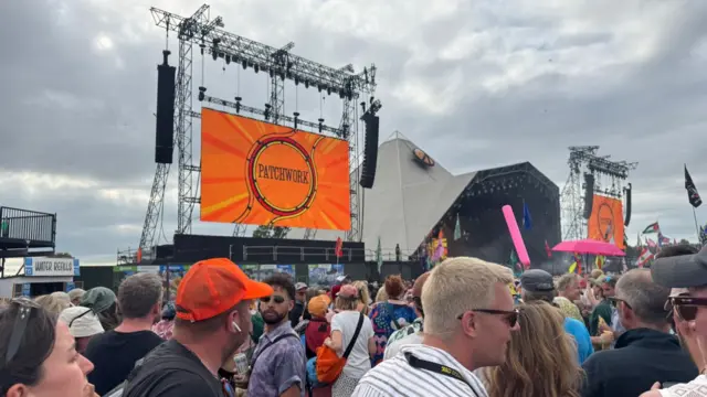 a stage with a logo reading 'patchwork' is seen with a crowd of festival goers
