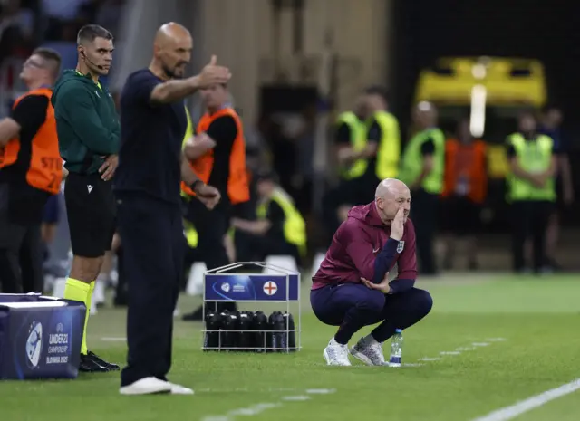Both managers stand on the touchline in their technical areas