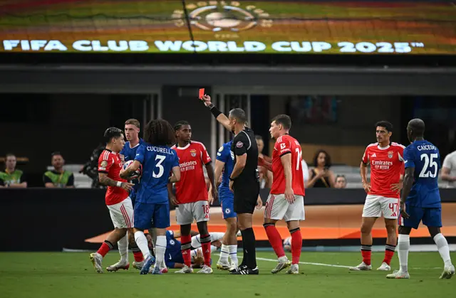 The referee brandishes a red card