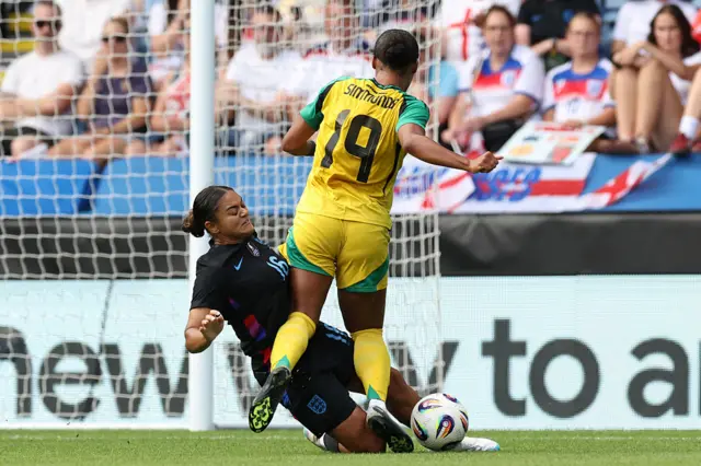 England's defender #16 Jess Carter (L) tackles Jamaica's Kameron Simmonds (R) during the Women's International friendly football match between England and Jamaica at King Power Stadium in Leicester, central England on June 29, 2025.