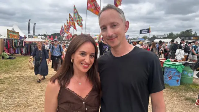 A man and a woman smile at the camera