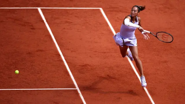 Zheng Qinwen plays a forehand return