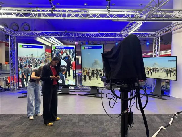 BBC Verify's Merlyn Thomas looks at her phone as she prepares to talk to the BBC News Channel