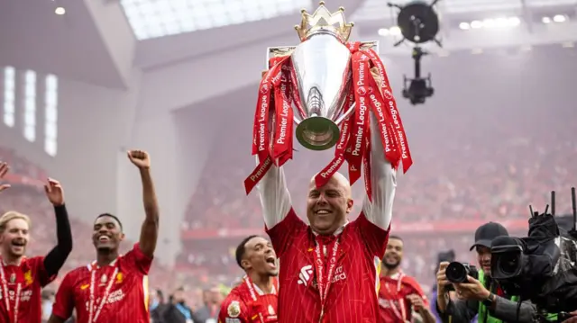 Manager Arne Slot celebrates with Premier League trophy