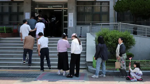 South Korean voters line up outside a polling station.