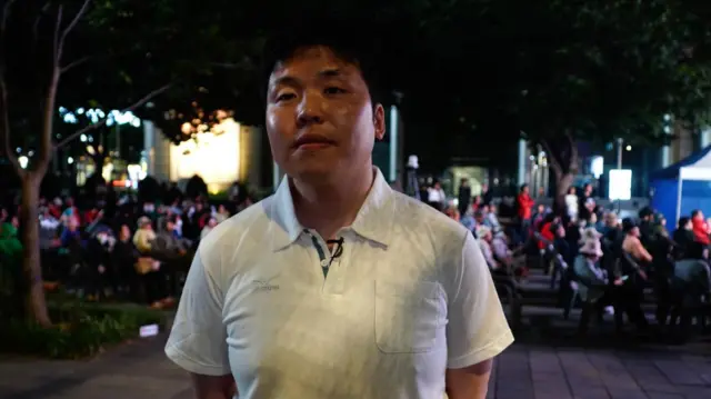Jeon Jae-hee, seen here in white polo tee, is part of an anti-Lee Jae-myung rally that has gathered in downtown Gwanghwamun