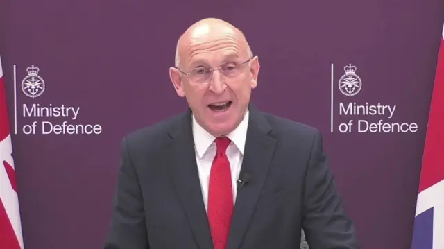 Defence Secretary John Healey appearing on BBC Breakfast in front of a board with two Ministry of Defence logos on it and between two union flags