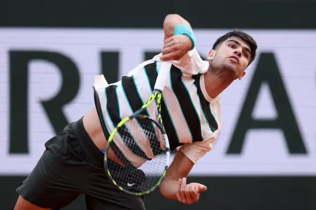Carlos Alcaraz serves