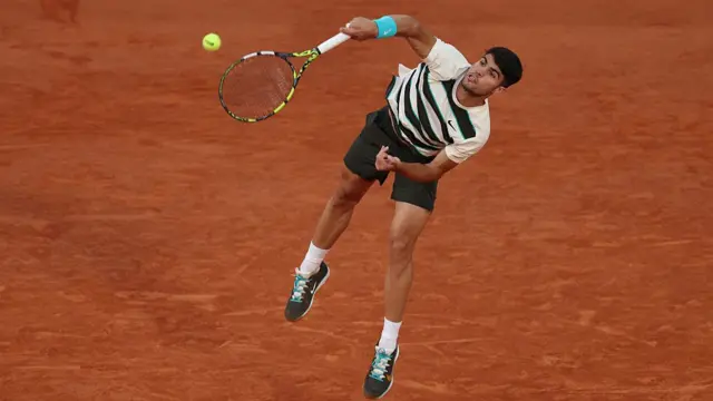 Carlos Alcaraz serves