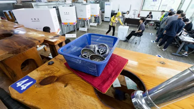 A Korean barbecue restaurant table is in front of a polling booth