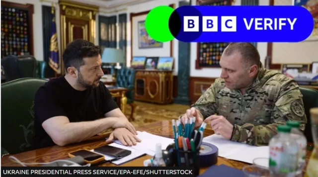 Ukrainian President Volodymyr Zelensky sat at a desk with a man in military uniform.