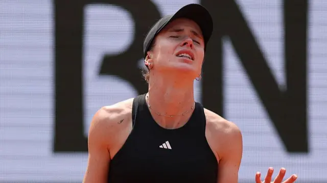 Elina Svitolina reacts and throws her hands in the air