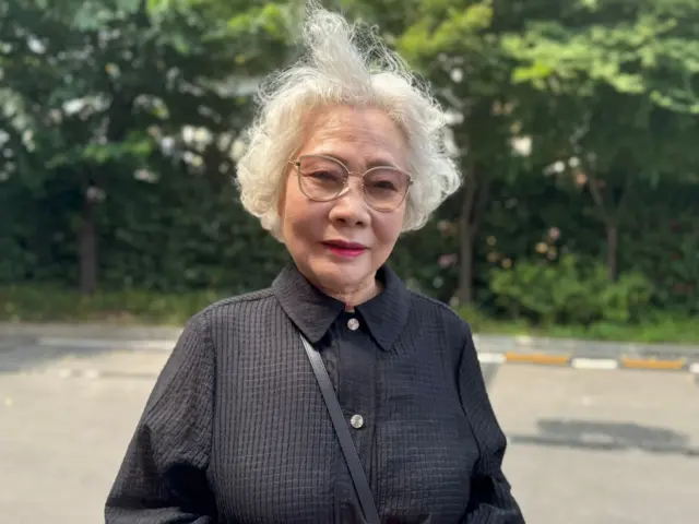 An 80-year-old lady standing in front of a polling station
