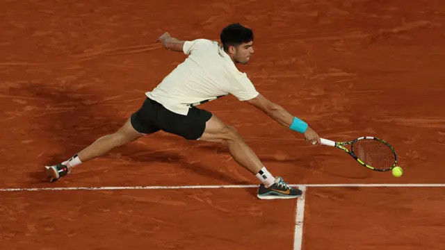 Carlos Alcaraz stretches to play a backhand