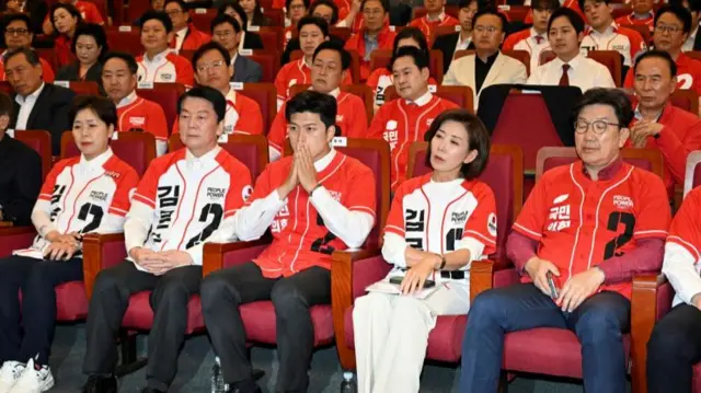 Lawmakers of the People Power Party look dejected as they watch a televised report of exit polls