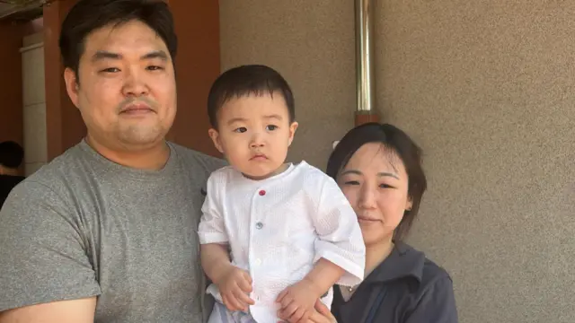 Korean couple holding their baby