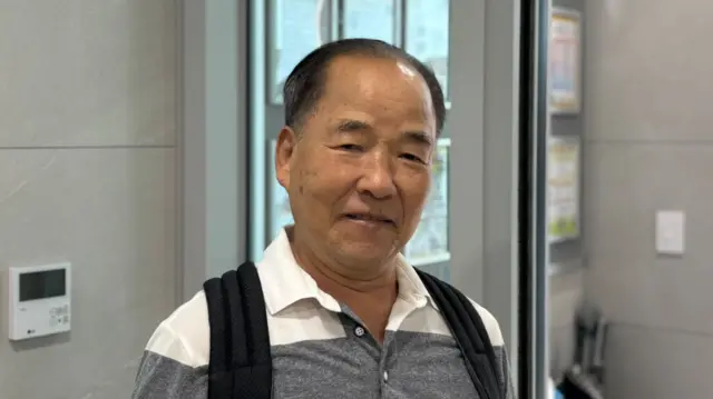 Yoo Jae-woo looks at the camera outside a polling station in Seoul, South Korea.
