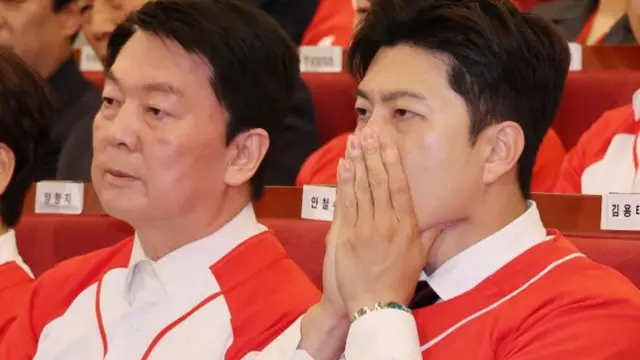 Kim Yong-tae (right), leader of the PPP's emergency leadership committee, clasps both hands over his mouth as he watches the results