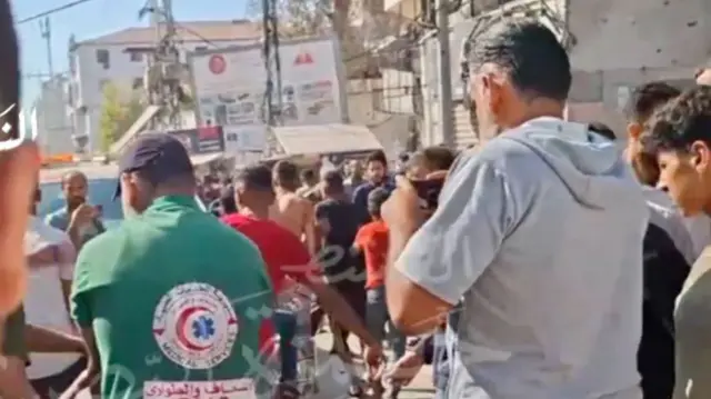 A screengrab showing paramedics and onlookers at the scene