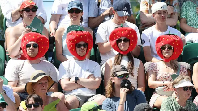 Spectators watching at Wimbledon in Strawberry hats