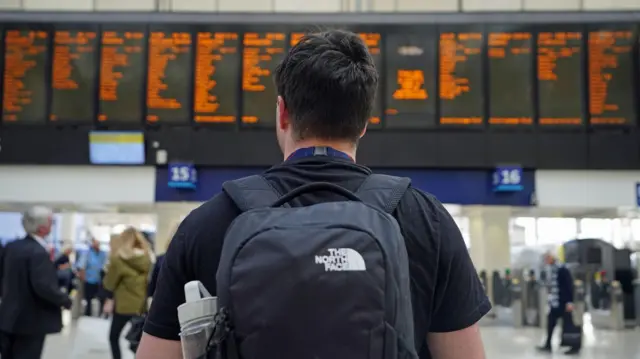 File photo dated 29/09/22 of a passenger looking at the travel boards at Waterloo Station in London. Rail passengers across Britain face disruption due to a fault with a radio system used by train drivers and signallers. Issue date: Friday December 6, 2024