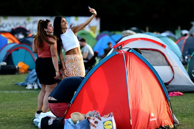 Two women pose for a selfie on the lawns of The Queue outside the Wimbledon tennis championships