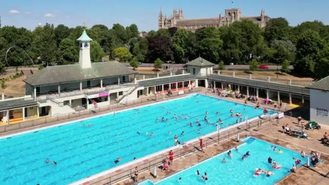 View of two large open air swimming pools in front of Peterborough cathedral