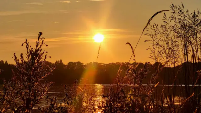 The sun peaks through over a reservoir in the Nottinghamshire village of Sutton-in-Ashfield