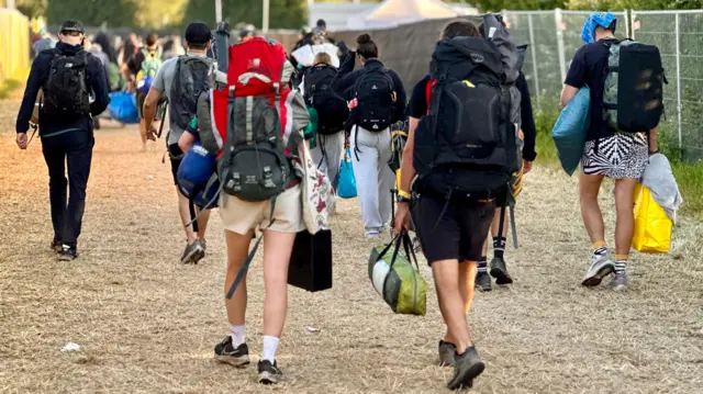Crowds heading home at Glastonbury with backpacks on