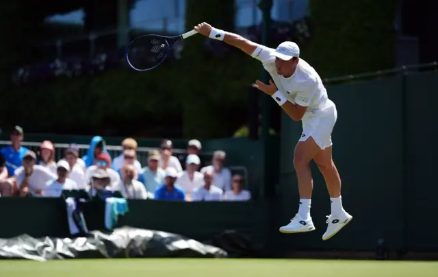 Oliver Crawford serves at Wimbledon