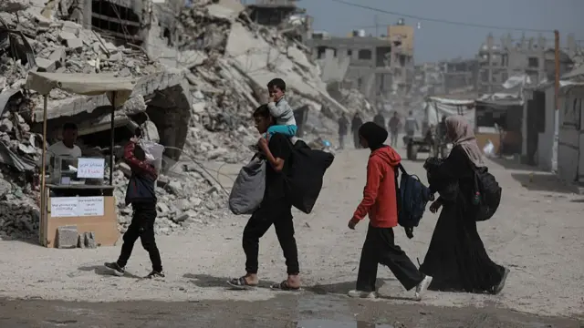 An image of people walking with their belongings.
