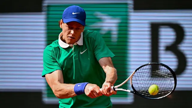 Jannik Sinner plays a backhand return
