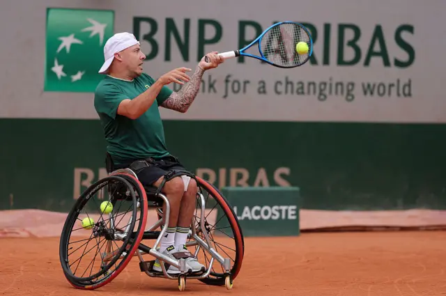 Andy Lapthorne hits a ball with his racquet