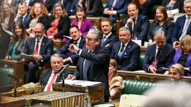 Keir starmer stands in parliament. MPs can be seen sitting behind him