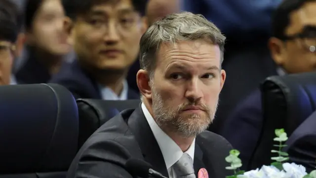 US Trade Representative Jamieson Greer wears a suit and looks to the side.